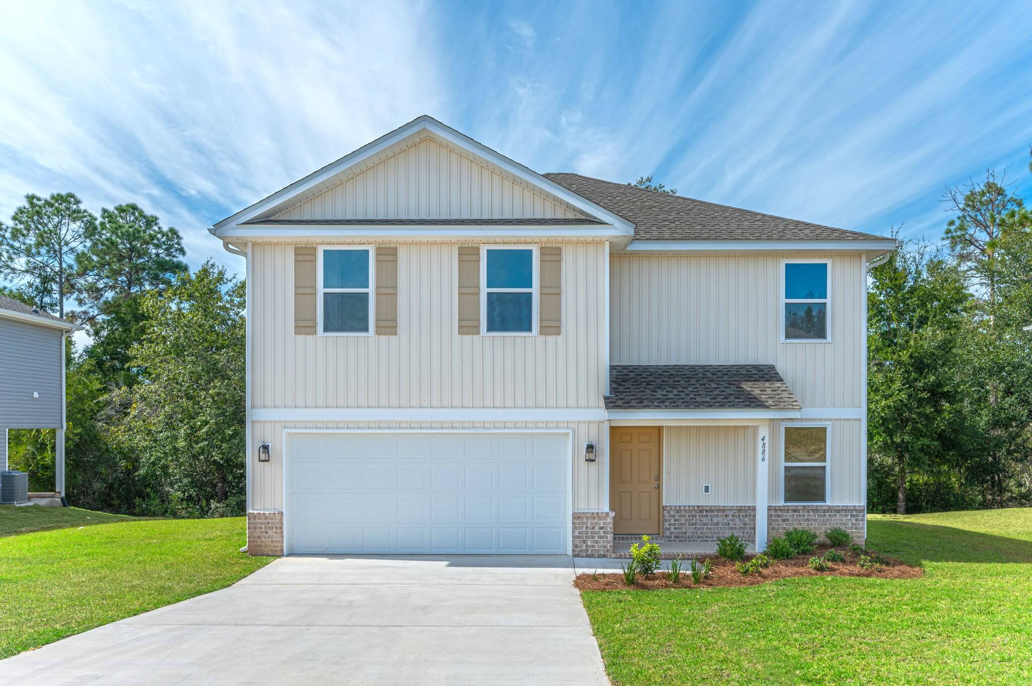 Exterior elevation of the Orange Blossom, a 2 story house with a 2-car garage on the left, small covered porch on the right, and 2 windows above the garage, 1 window above the porch, and 1 window on the first floor right side